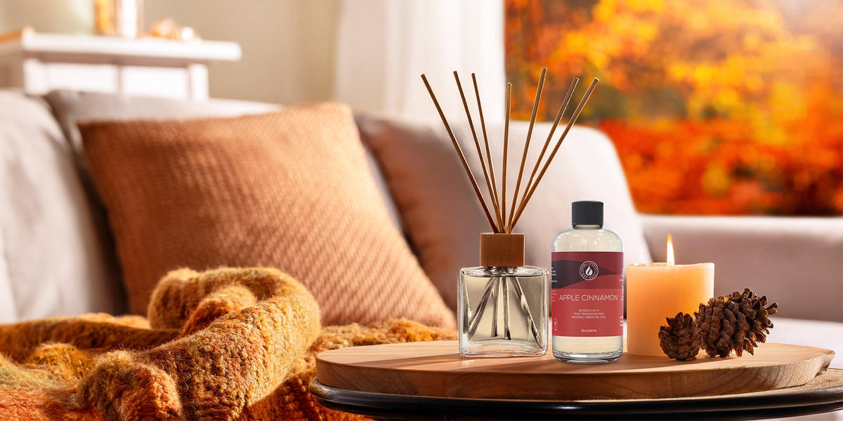 A living room with knit pillows, pinecones and warm fall decor